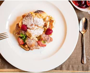 Ein Romantik Chefkoch serviert Kaiserschmarren mit Beeren in einem Genusshotel Ein Romantik Chefkoch serviert Kaiserschmarren mit Beeren in einem Genusshotel