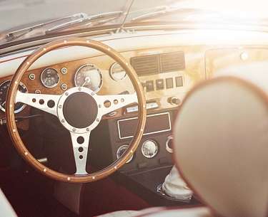 Das Lenkrad eines Oldtimers im Sonnenlicht Das Lenkrad eines Oldtimers im Sonnenlicht