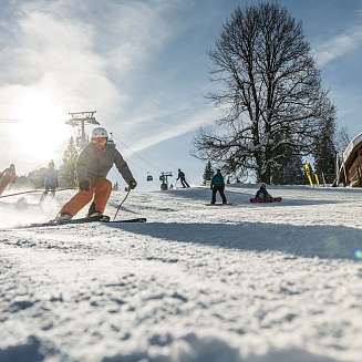 Holzhütten mit Schnee bedeckt bei klarem Himmel in einer Winterlandschaft