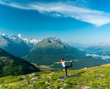 Eine junge Frau macht auf einem Berg nahe eines Wellnesshotels Yoga im Sommer Eine junge Frau macht auf einem Berg nahe eines Wellnesshotels Yoga im Sommer