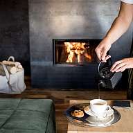 In einem exklusiven Wellnesshotel wird Tee an einem Lagerfeuer eingeschenkt 