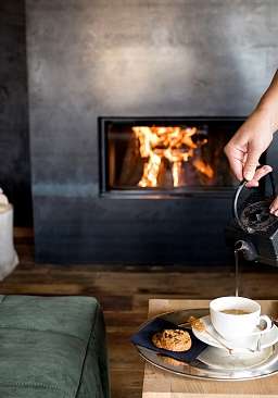In einem exklusiven Wellnesshotel wird Tee an einem Lagerfeuer eingeschenkt  In einem exklusiven Wellnesshotel wird Tee an einem Lagerfeuer eingeschenkt