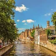 Ausblick auf einen Kanal mit Häusern an den Seiten und einigen Schiffen auf dem Fluss in Belgien Ausblick auf einen Kanal mit Häusern an den Seiten und einigen Schiffen auf dem Fluss in Belgien