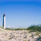 Ein Leuchtturm an der Nordsee hinter einer Sanddüne