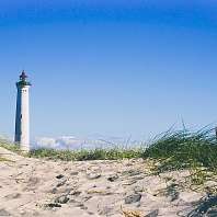 Ein Leuchtturm an der Nordsee hinter einer Sanddüne