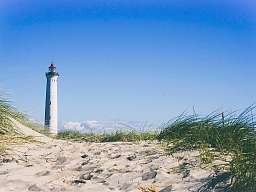 Ein Leuchtturm an der Nordsee hinter einer Sanddüne