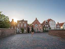 Schmucke Nordseestädte Frau springt auf einer Brücke an der Nordsee