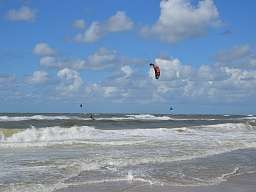 Kitesurfen Nordsee Ein Kitesurfer nimmt eine Welle auf der Nordsee