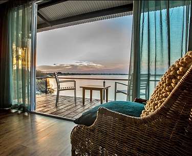 Gemütlicher Sessel in der Zambezi Mubala Lodge mit Blick auf den Sambesi, Namibia Gemütlicher Sessel in der Zambezi Mubala Lodge mit Blick auf den Sambesi, Namibia