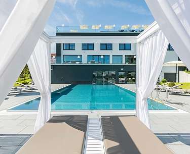 Eine Poolliege mit Vorhang an einem Außenpool eines Romantik Hotels in Europa Eine Poolliege mit Vorhang an einem Außenpool eines Romantik Hotels in Europa