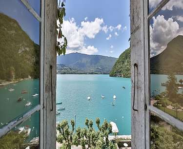 Blick aus einem Fenster eines schönen Hotels in Frankreich auf einen See Blick aus einem Fenster eines schönen Hotels in Frankreich auf einen See