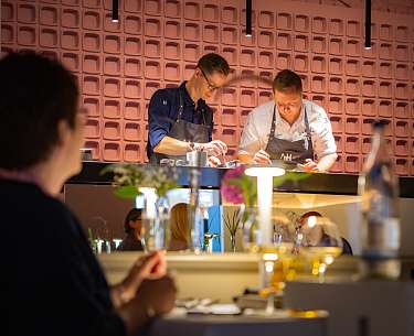 Zwei Spitzenköche kochen in einer offenen Küche vor den Gästen des Hotels Zwei Spitzenköche kochen in einer offenen Küche vor den Gästen des Hotels