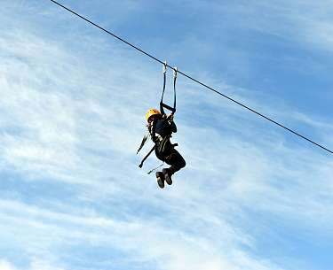 Zipline Person, die gerade an einer Zipline entlanggleitet