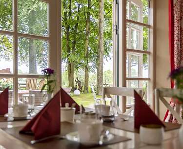 Frühstücksraum mit Blick in den grünen Garten