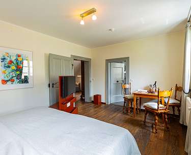 Blick auf ein Hotelzimmer mit Fernseher und Holzmöbeln