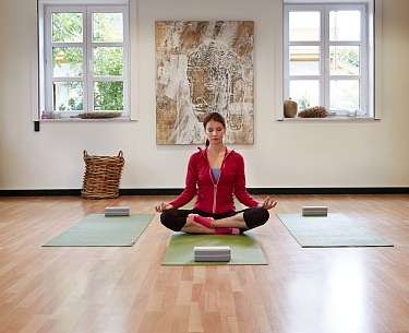 Yoga im Mühlbach Frau praktiziert Yoga-Sitz im Romantik Hotel Mühlbach