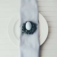 Ostern 2023 Osterei auf einer Serviette und einem weißen Teller