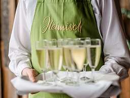 RH Reichshof Blick auf Servierteller mit Sektgläsern und grüner Schürze