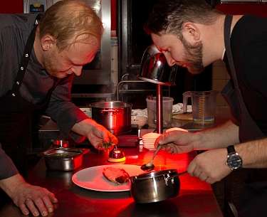 Küchenchefs beim Anrichten des Tellers Küchenchefs beim Anrichten des Tellers
