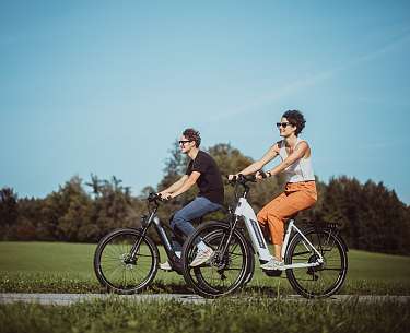 E-bike Tour um das Romantik Hotel Spa Hotel Elixhauser Wirt E-Bike und Rucksack auf einer grünen Wiese im Salzburgerland