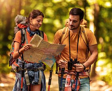 Pärchen auf einer Wanderung Pärchen auf einer Wanderung mit Wanderkarte