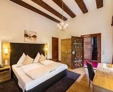 Freiherrenzimmer Blick auf das Bett und Kronleuchter im Freiherrenzimmer