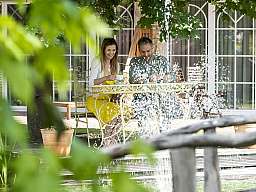 paar sitzt im garten am schlossteich v2